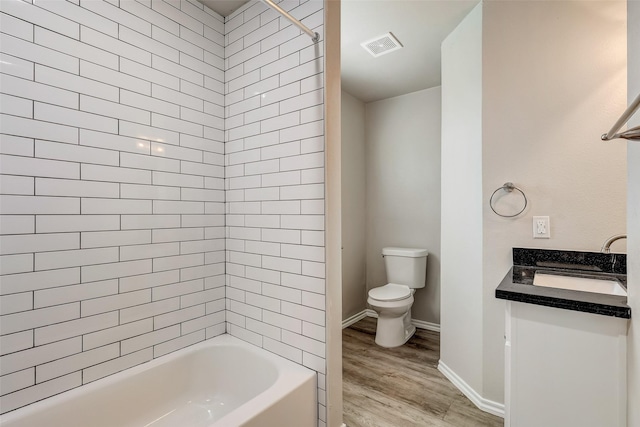 full bathroom featuring vanity, toilet, wood-type flooring, and tiled shower / bath