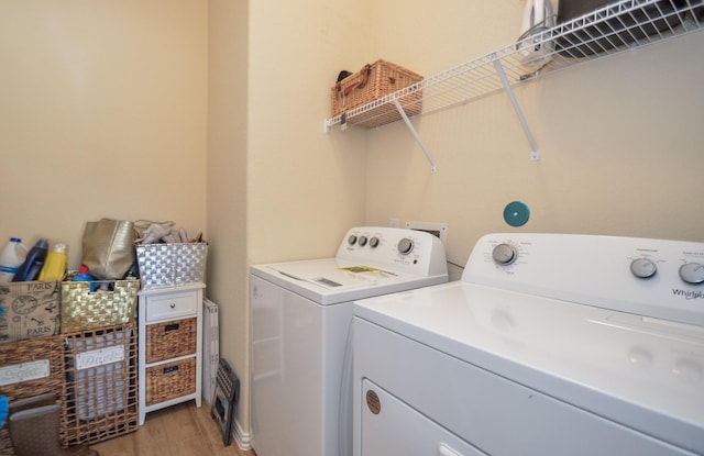 laundry room with washer and dryer and light hardwood / wood-style floors