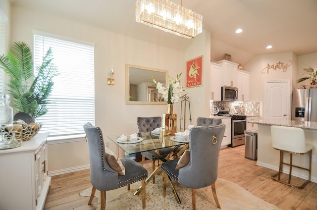 dining room with light hardwood / wood-style floors and lofted ceiling