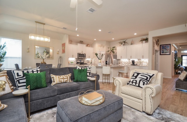 living room featuring ceiling fan and light wood-type flooring