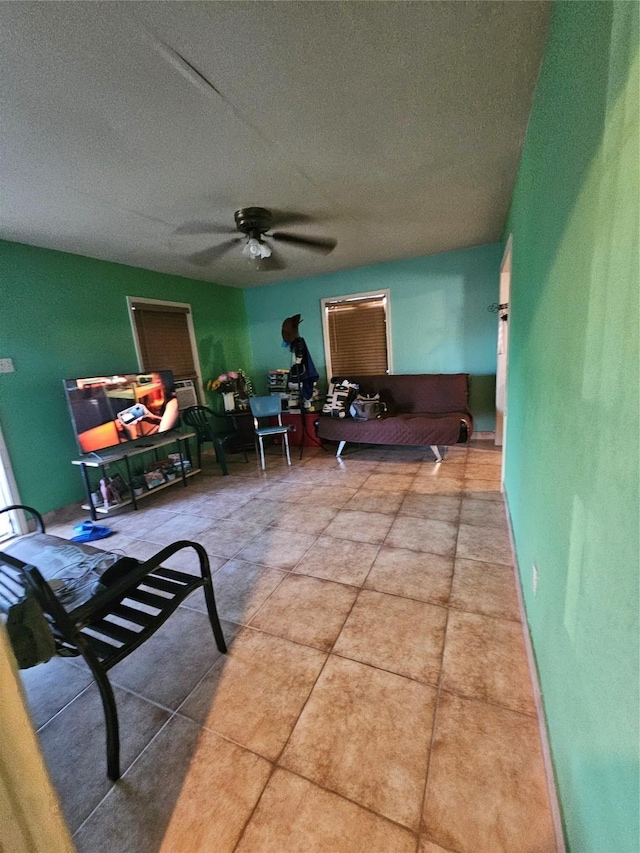 tiled living room featuring ceiling fan and a textured ceiling