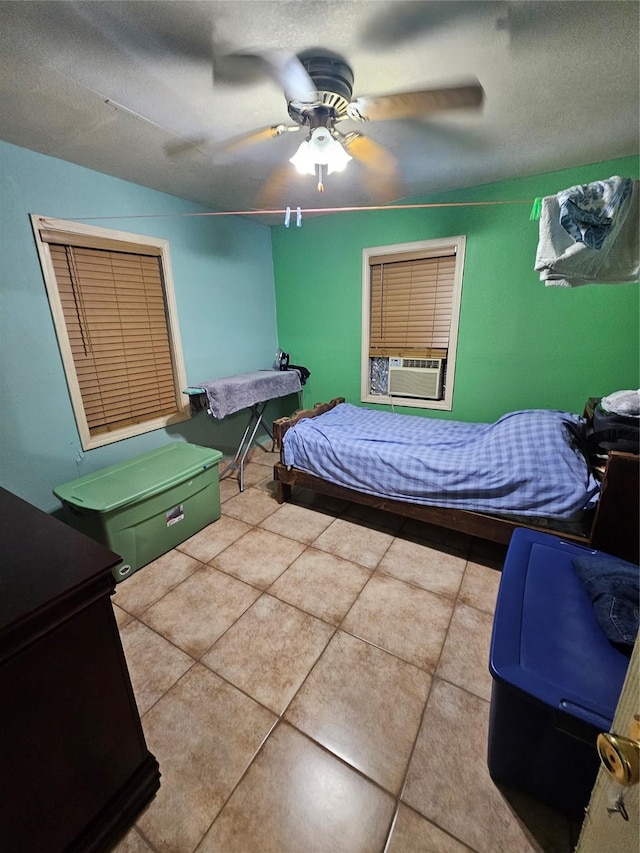 tiled bedroom with ceiling fan, cooling unit, and a textured ceiling