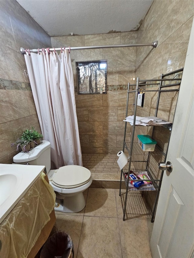 bathroom featuring tile patterned floors, walk in shower, vanity, a textured ceiling, and toilet