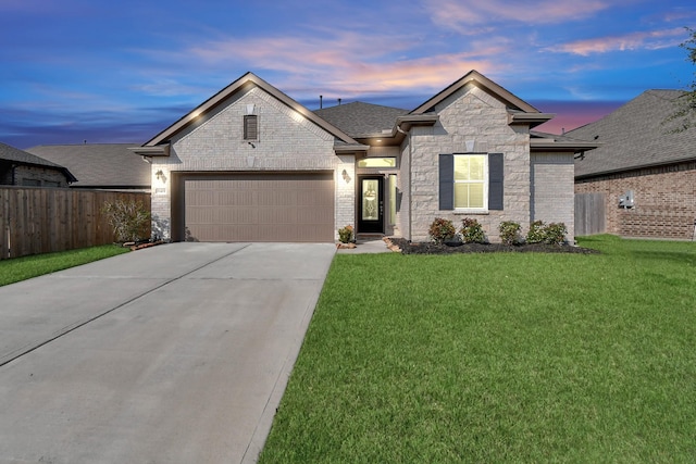 view of front of home with a garage and a lawn