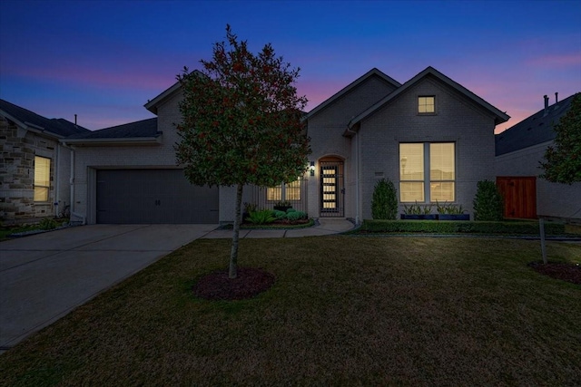 front facade featuring a garage and a lawn