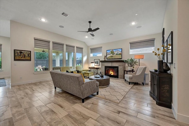 living room featuring a tile fireplace and ceiling fan