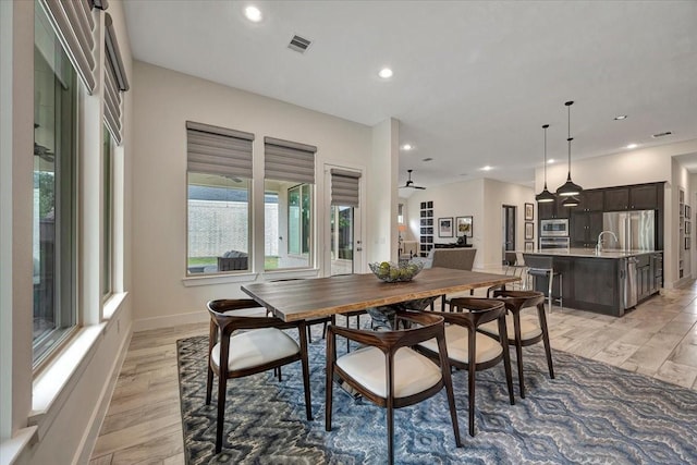 dining space featuring light hardwood / wood-style flooring, ceiling fan, and sink