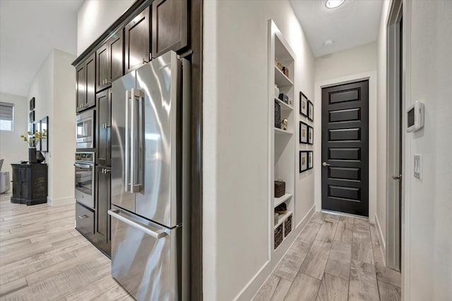 kitchen with dark brown cabinetry and appliances with stainless steel finishes