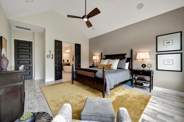 bedroom featuring ceiling fan, high vaulted ceiling, ensuite bathroom, and light wood-type flooring