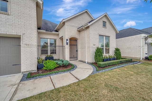 doorway to property featuring a garage and a lawn