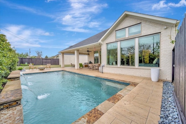 view of pool with pool water feature, ceiling fan, and a patio