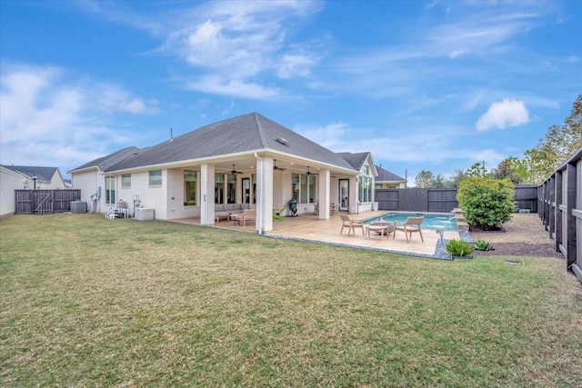 rear view of house with a fenced in pool, ceiling fan, a patio area, and a lawn