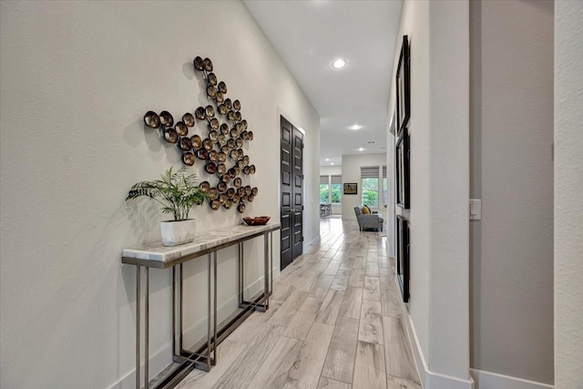 hallway with light hardwood / wood-style floors