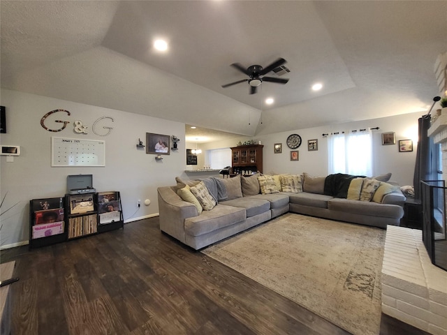 living room with dark hardwood / wood-style flooring, a tray ceiling, vaulted ceiling, and ceiling fan