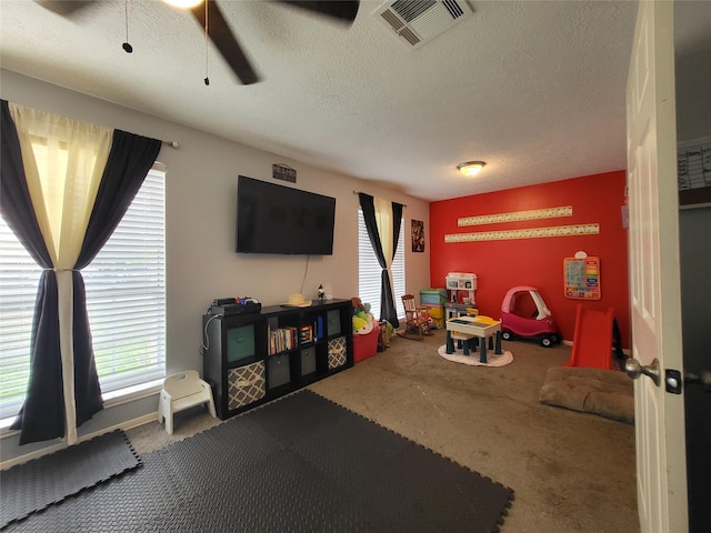 game room with carpet flooring, ceiling fan, plenty of natural light, and a textured ceiling