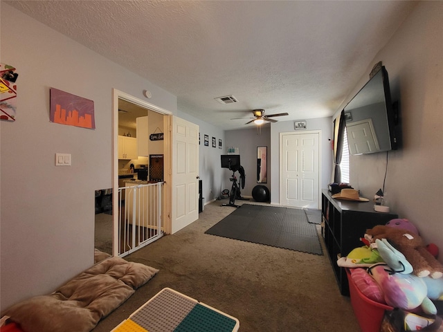 living room featuring carpet, a textured ceiling, and ceiling fan