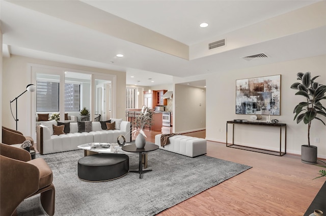 living room with a wealth of natural light and light hardwood / wood-style flooring