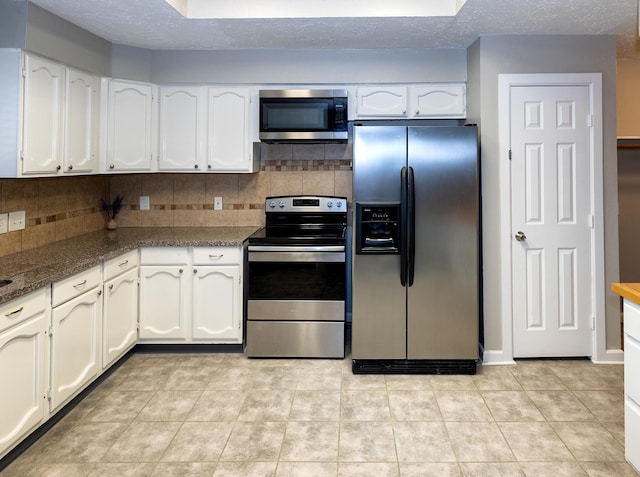 kitchen featuring white cabinets, light tile patterned floors, a textured ceiling, appliances with stainless steel finishes, and tasteful backsplash