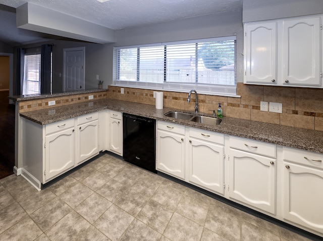 kitchen featuring backsplash, white cabinets, dark stone counters, sink, and dishwasher