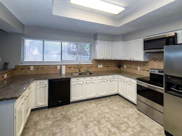 kitchen with a raised ceiling, white cabinetry, sink, and appliances with stainless steel finishes