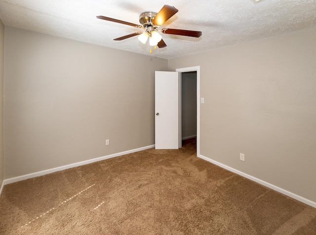 carpeted spare room featuring ceiling fan and a textured ceiling