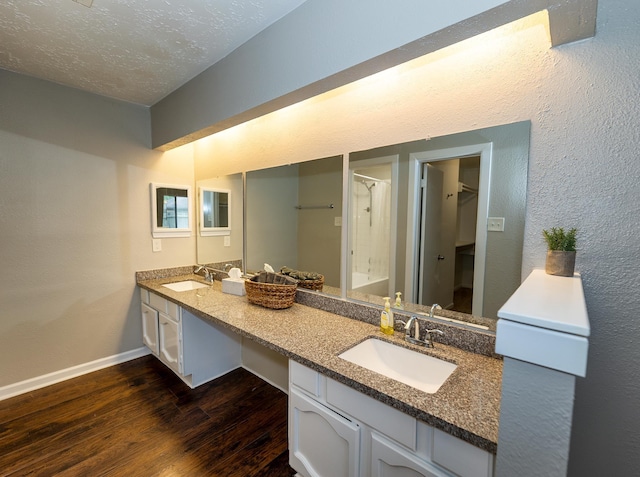 bathroom with hardwood / wood-style floors, vanity, and a textured ceiling