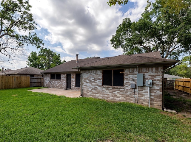 back of property featuring a yard and a patio