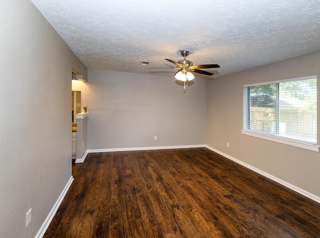 empty room featuring dark hardwood / wood-style floors, ceiling fan, and a textured ceiling