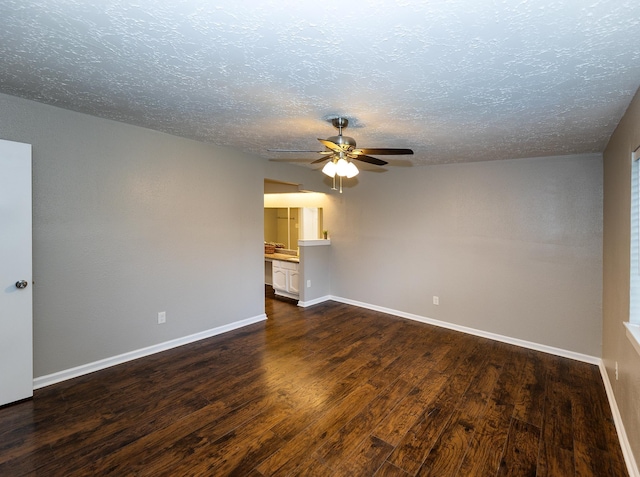 spare room with a textured ceiling, dark hardwood / wood-style flooring, and ceiling fan