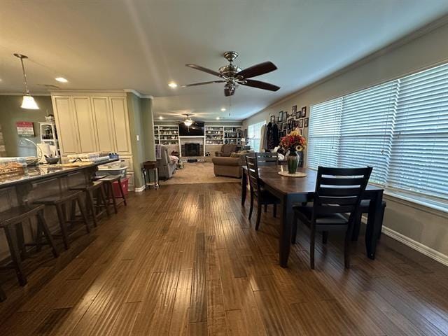 dining space with a wealth of natural light, dark hardwood / wood-style floors, ceiling fan, and crown molding