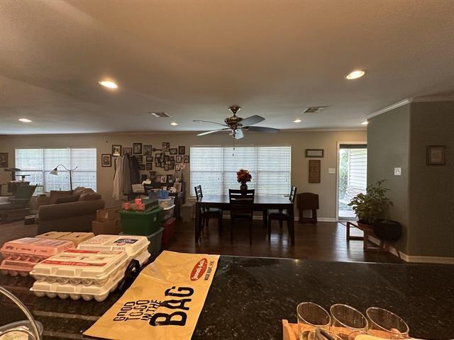 interior space with ceiling fan and ornamental molding