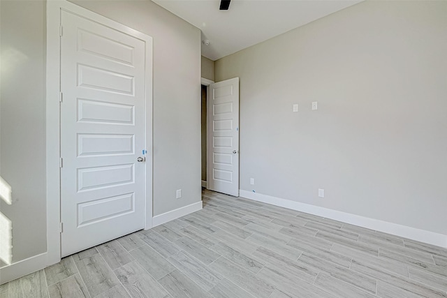 unfurnished bedroom with light hardwood / wood-style flooring and a closet