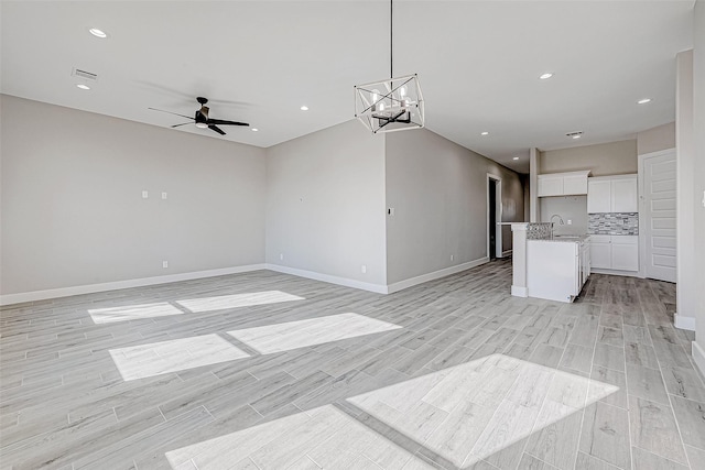 interior space with sink, light hardwood / wood-style floors, and ceiling fan with notable chandelier