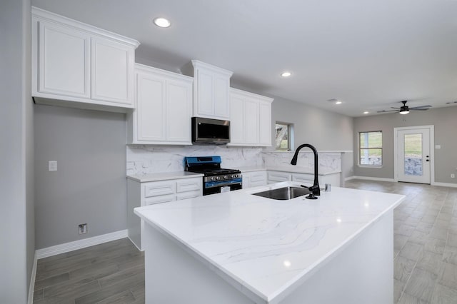 kitchen featuring white cabinetry, an island with sink, appliances with stainless steel finishes, and sink