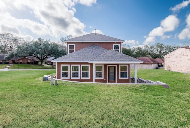 rear view of property featuring a yard