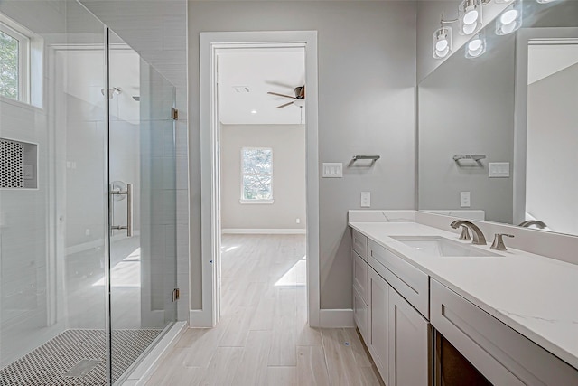 bathroom featuring ceiling fan, a shower with shower door, and vanity