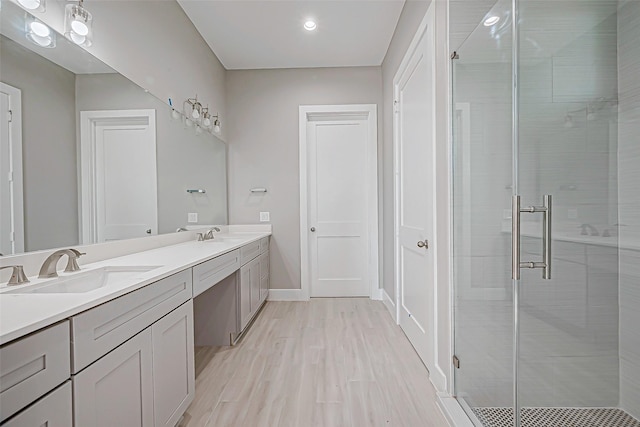 bathroom with a shower with door, vanity, and hardwood / wood-style floors