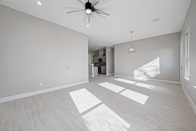 unfurnished living room featuring ceiling fan and light hardwood / wood-style floors