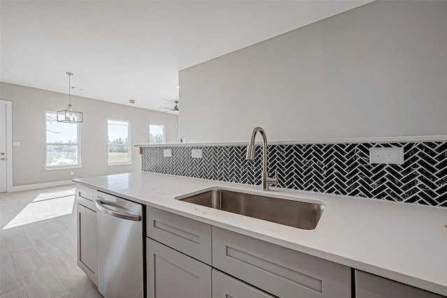 kitchen with dishwasher, gray cabinets, light stone counters, and sink