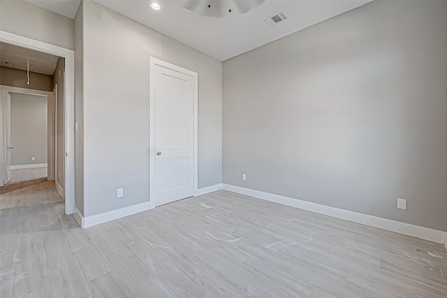 unfurnished bedroom with ceiling fan, light wood-type flooring, and a closet