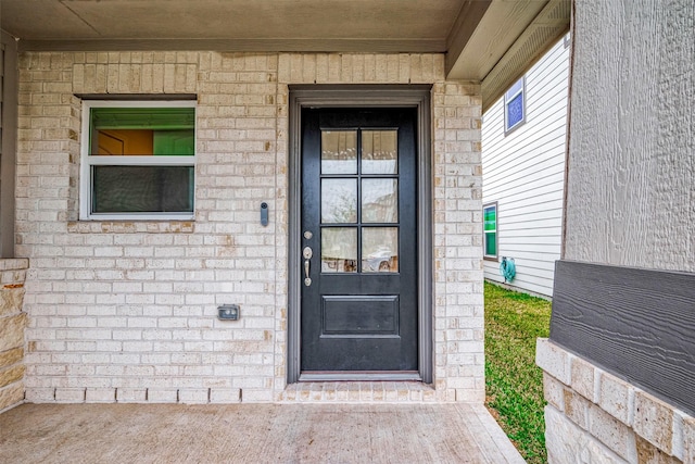 entrance to property featuring brick siding