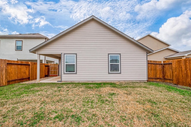 back of house featuring a fenced backyard, a lawn, and a patio