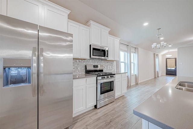 kitchen featuring white cabinets, stainless steel appliances, and light countertops