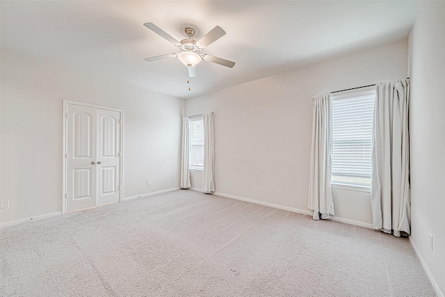 unfurnished room with light carpet, ceiling fan, and baseboards