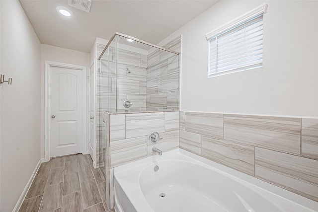 full bathroom with a stall shower, visible vents, baseboards, a garden tub, and wood tiled floor