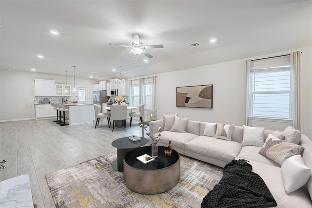 living area featuring light wood-type flooring, visible vents, a ceiling fan, and recessed lighting