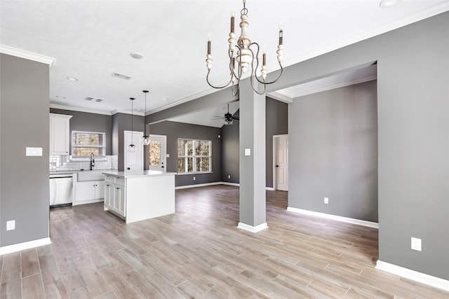 kitchen with white cabinets, ceiling fan with notable chandelier, dishwasher, a kitchen island, and hanging light fixtures