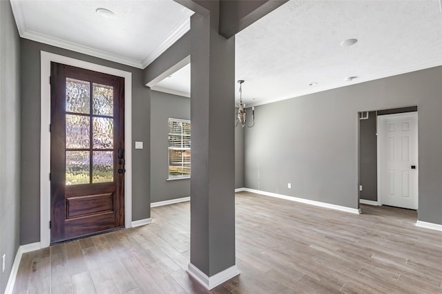 foyer featuring crown molding, light hardwood / wood-style flooring, and a chandelier