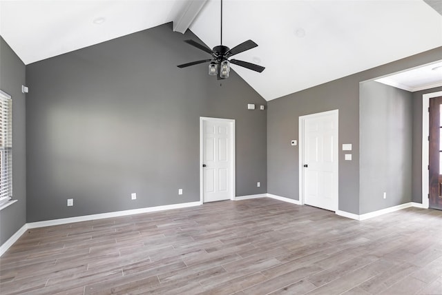 unfurnished living room featuring ceiling fan, light hardwood / wood-style flooring, beamed ceiling, and high vaulted ceiling