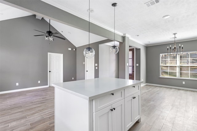 kitchen featuring pendant lighting, vaulted ceiling with beams, white cabinetry, and a kitchen island